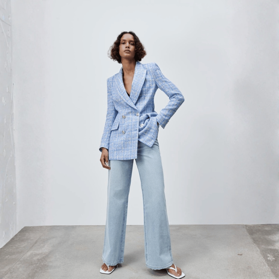 Woman wearing a light blue suit with a plain background