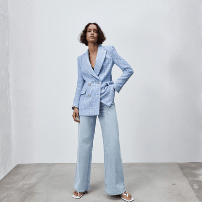 Woman wearing a light blue suit with a plain background