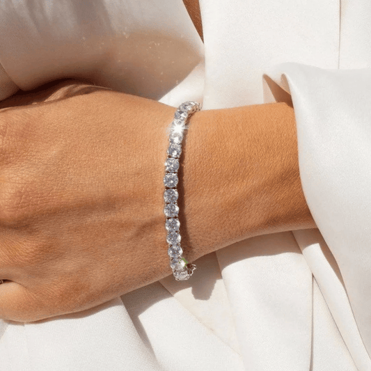 Silver bracelet on a wrist with a white background