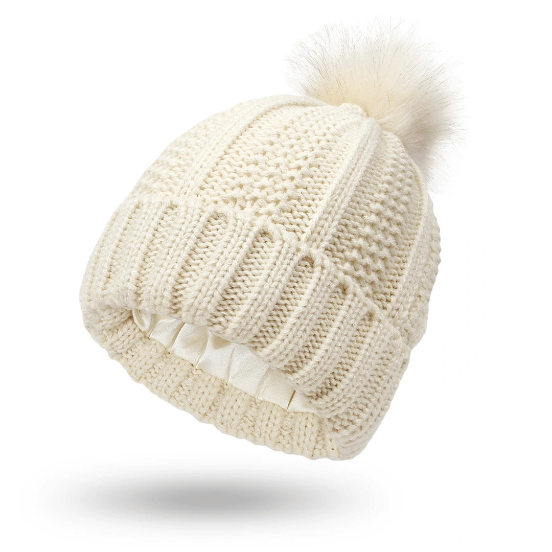 Knitted beanie with a pom-pom on a white background