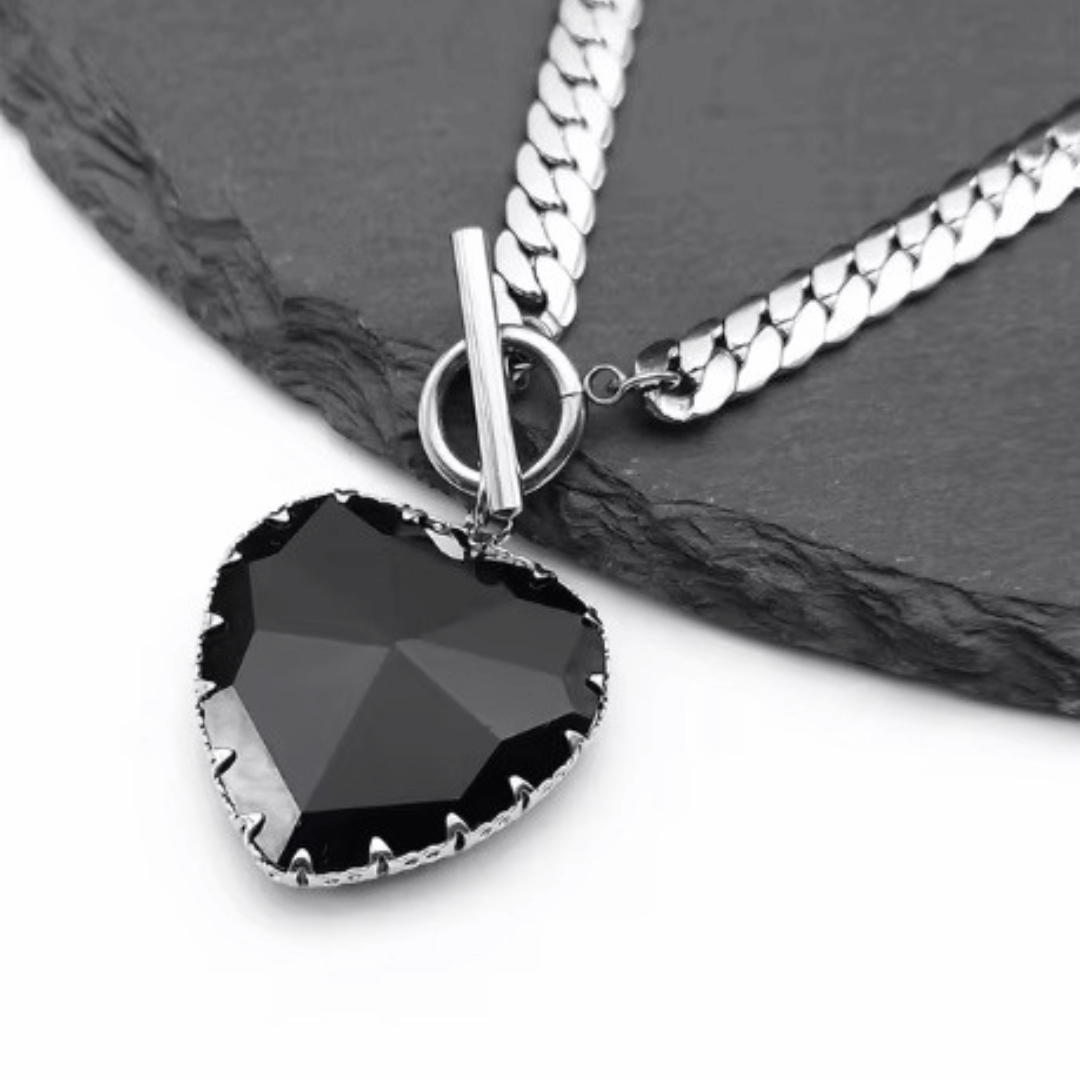 Necklace with a black heart-shaped pendant on a dark surface