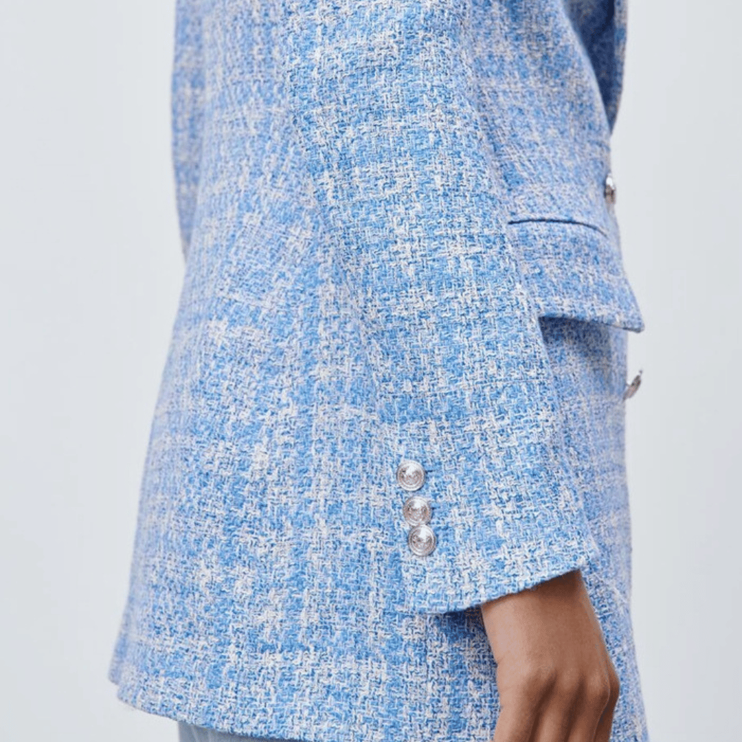 Close-up of a blue and white patterned coat with buttons on a light gray background