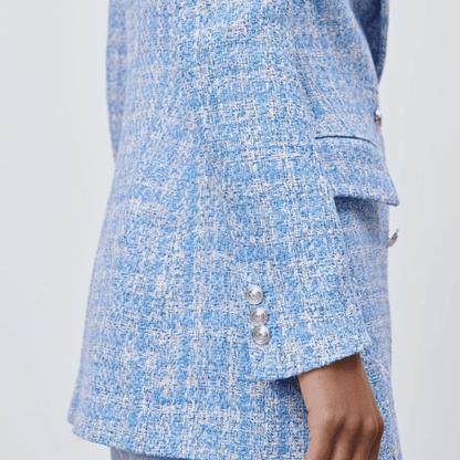 Close-up of a blue and white patterned coat with buttons on a light gray background