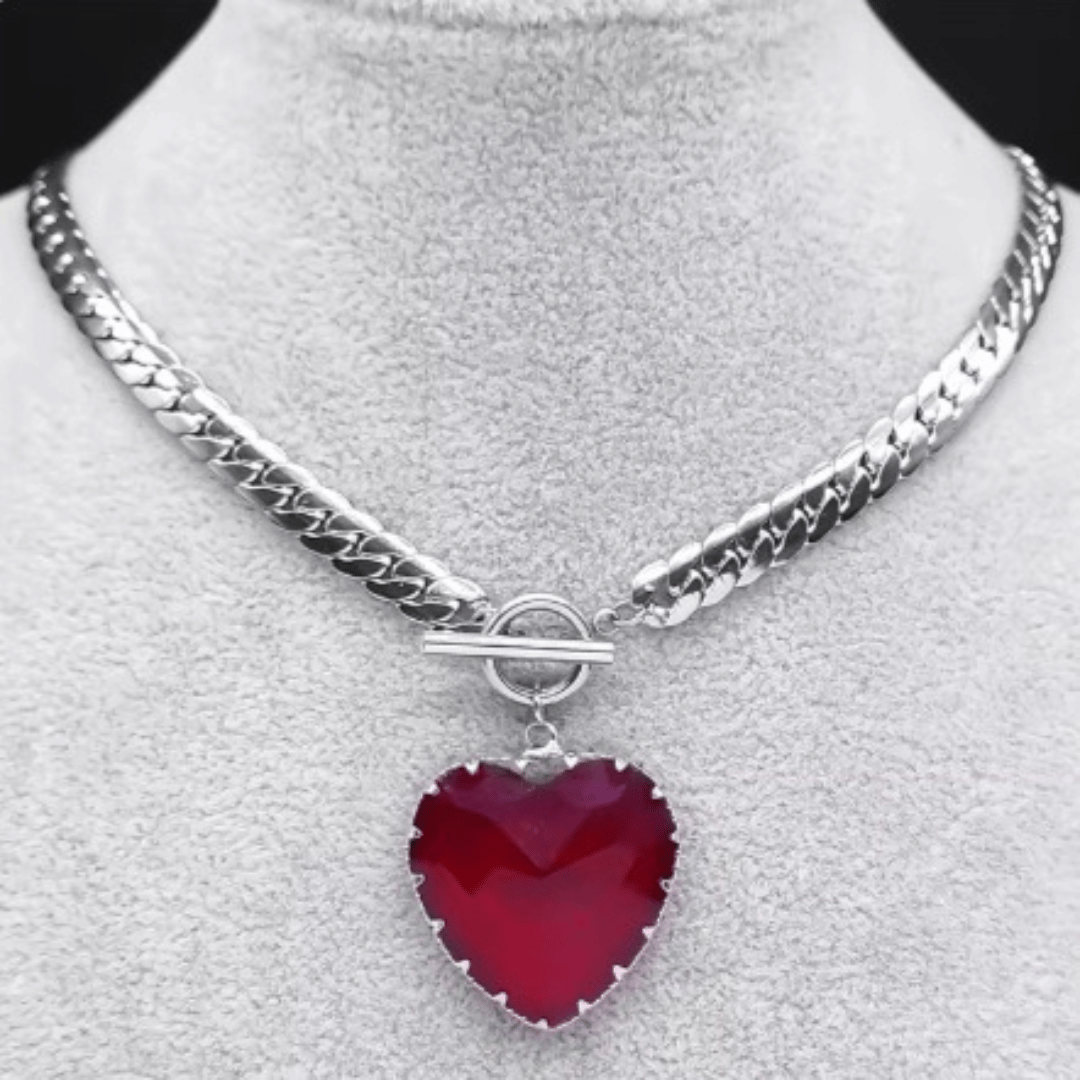 Silver necklace with a red heart pendant on a gray background