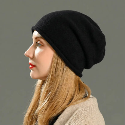 Woman wearing a black beanie against a gray background