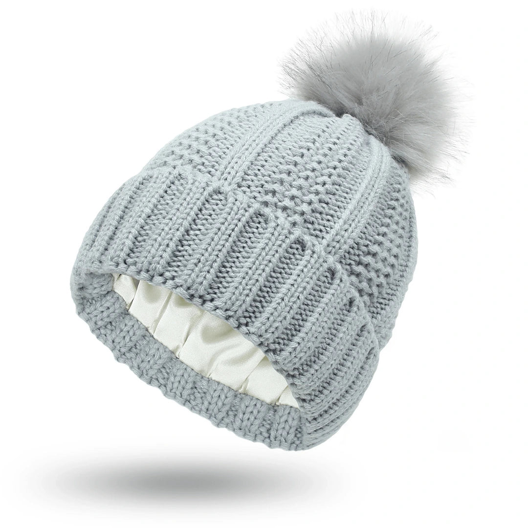 Knitted beanie with a pom-pom on a white background