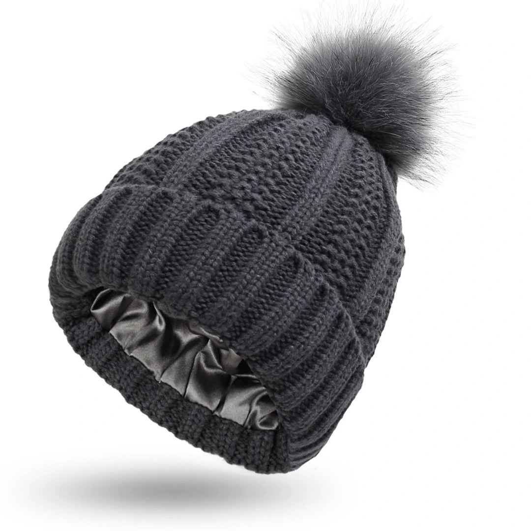 Gray knit beanie with a fur pom-pom on a white background