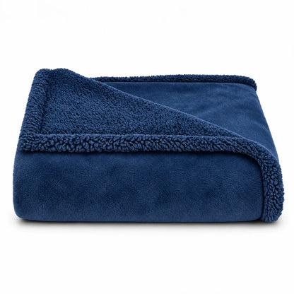 A folded navy blue fleece blanket with a plush sherpa lining, shown on a clean white background.