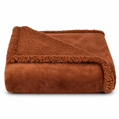 A folded brown fleece blanket with a soft sherpa lining, shown on a clean white background.