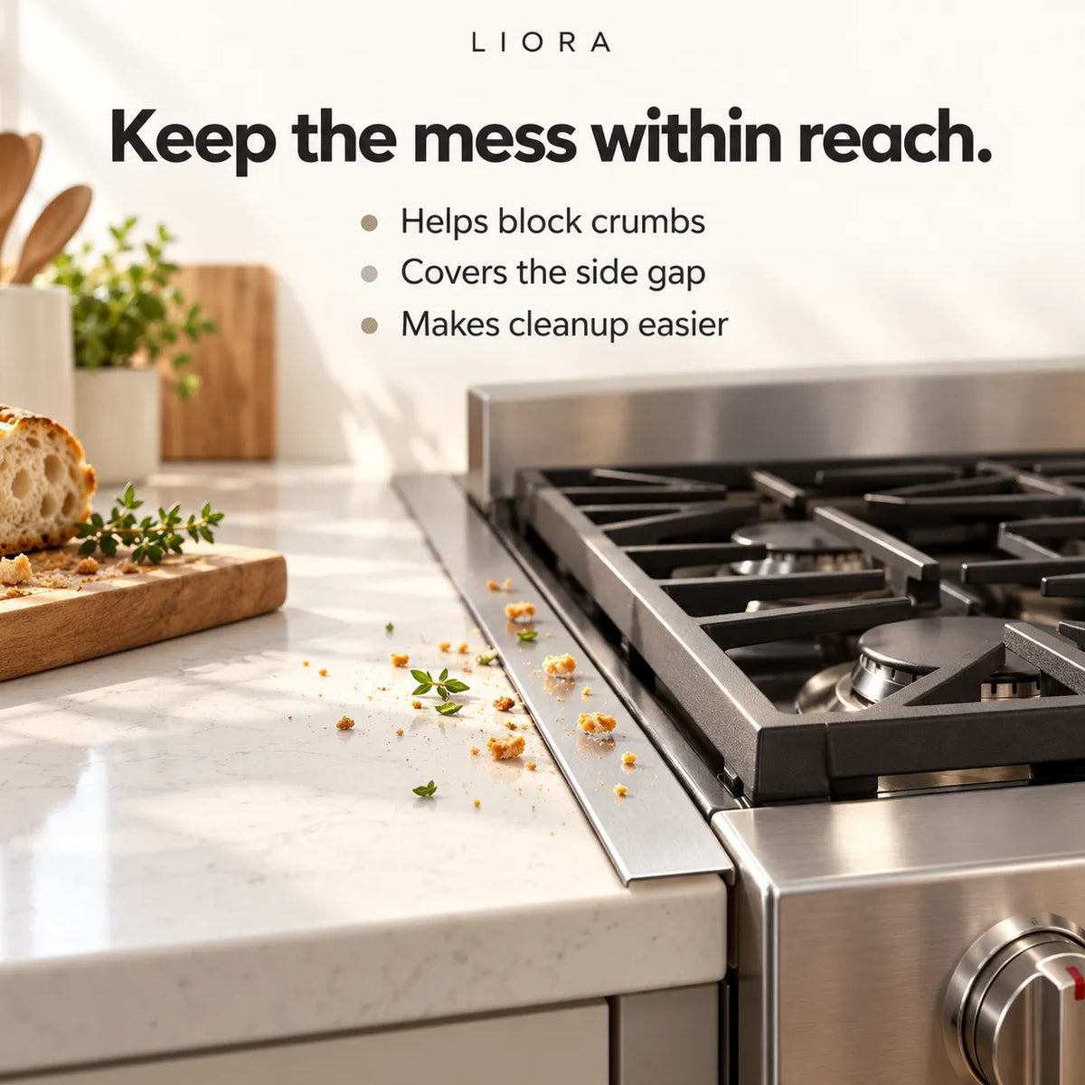 A stainless steel gas range with a built-in catchall tray along the front edge, shown in a bright kitchen setting with crumbs on the white countertop and text describing the product's cleaning benefit. The brand name LIORA appears at the top.