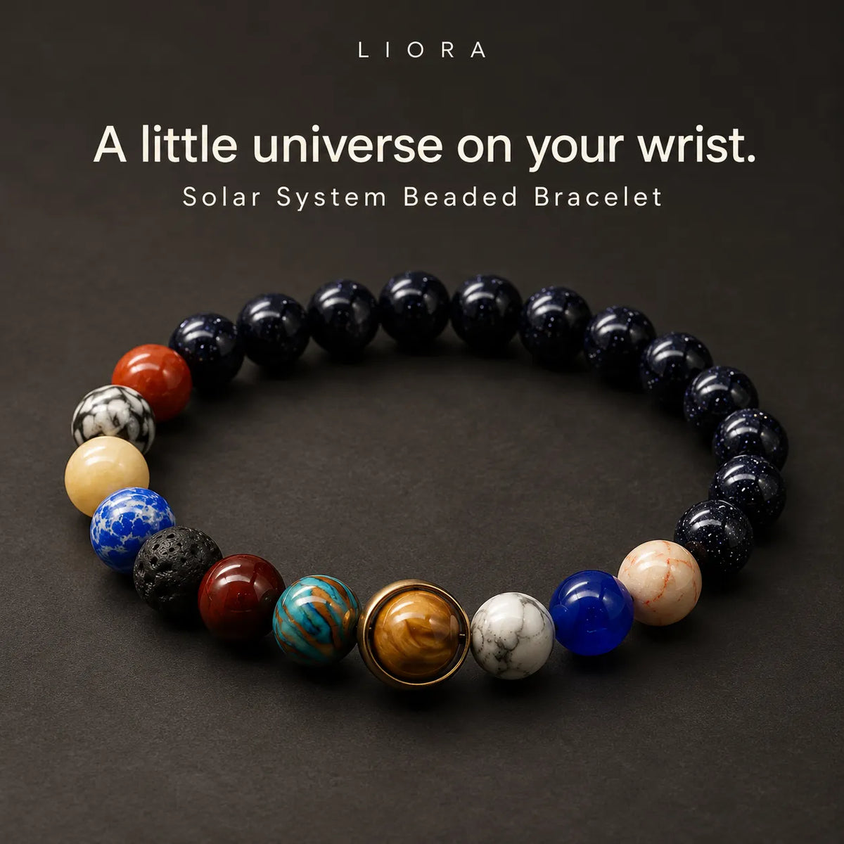 A beaded bracelet arranged in a circle on a dark background, featuring mostly black beads with several accent beads in red, cream, blue, brown, and white, plus a central gold-toned sun-like bead.