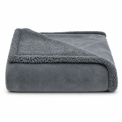 A folded gray fleece blanket with a sherpa lining, shown on a clean white background.