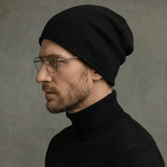 Man wearing a black beanie and turtleneck against a gray background